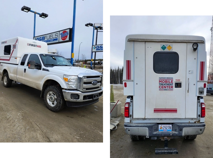 A white truck and a camper van parked at the gas station.