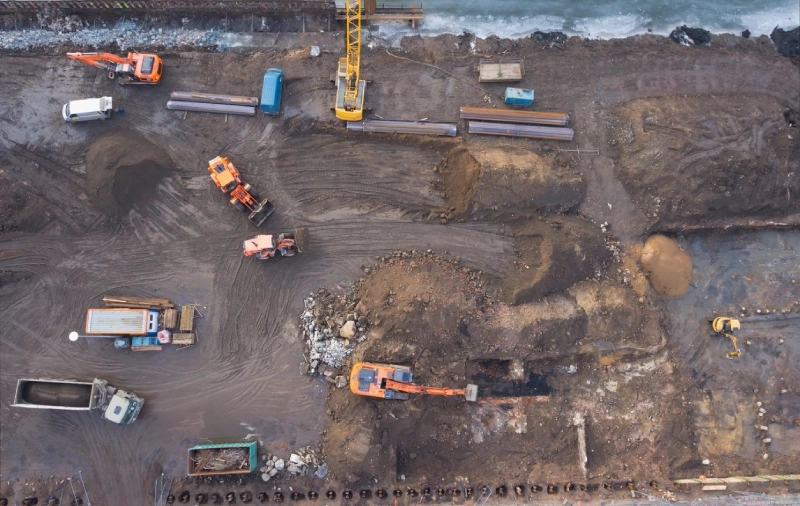 A construction site with many vehicles and equipment.