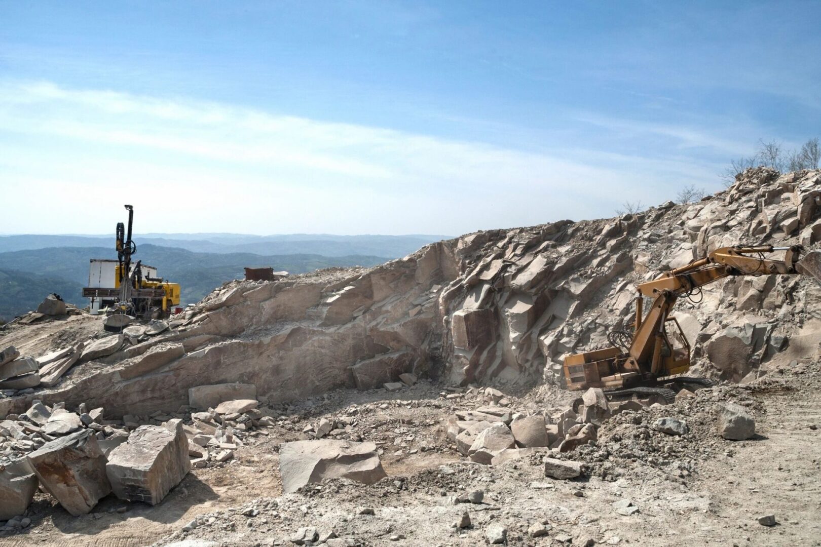 fm=f_25588 A large rock pile with a bulldozer on top of it.